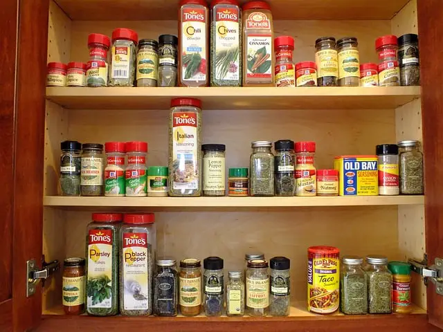 A spice rack with 50 jars and containers of various spices and herbs.